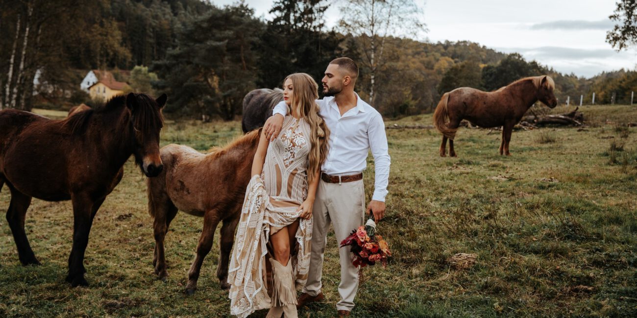 Brautpaar mit Pferden auf einer Wiese